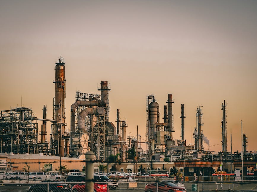 A large industrial power plant silhouetted against the warm hues of a sunset.